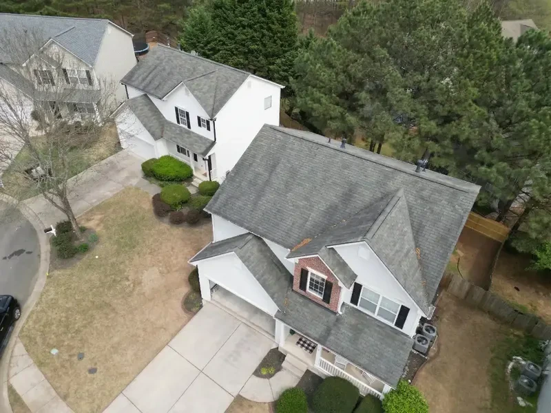 Two-story home with a worn gray shingle roof before replacement