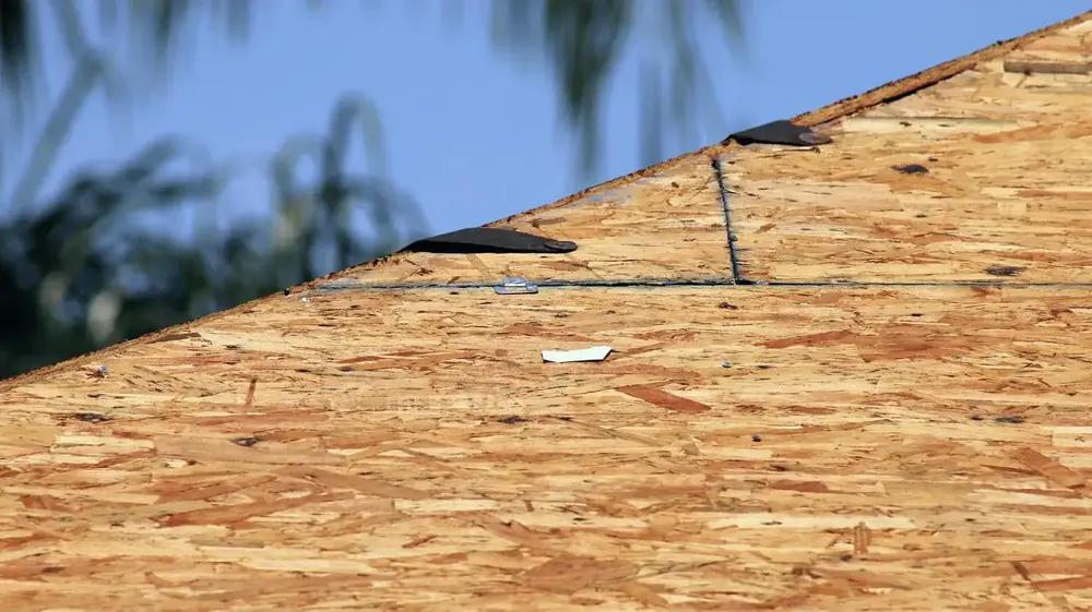 Close-up of exposed OSB roof decking during inspection
