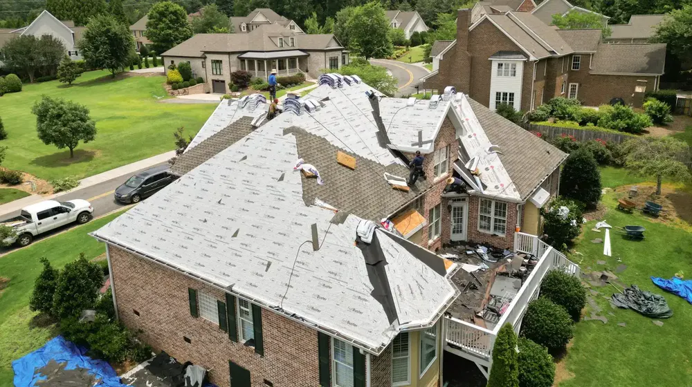 Aerial drone view of roof replacement in progress with FeltBuster synthetic underlayment covering the deck
